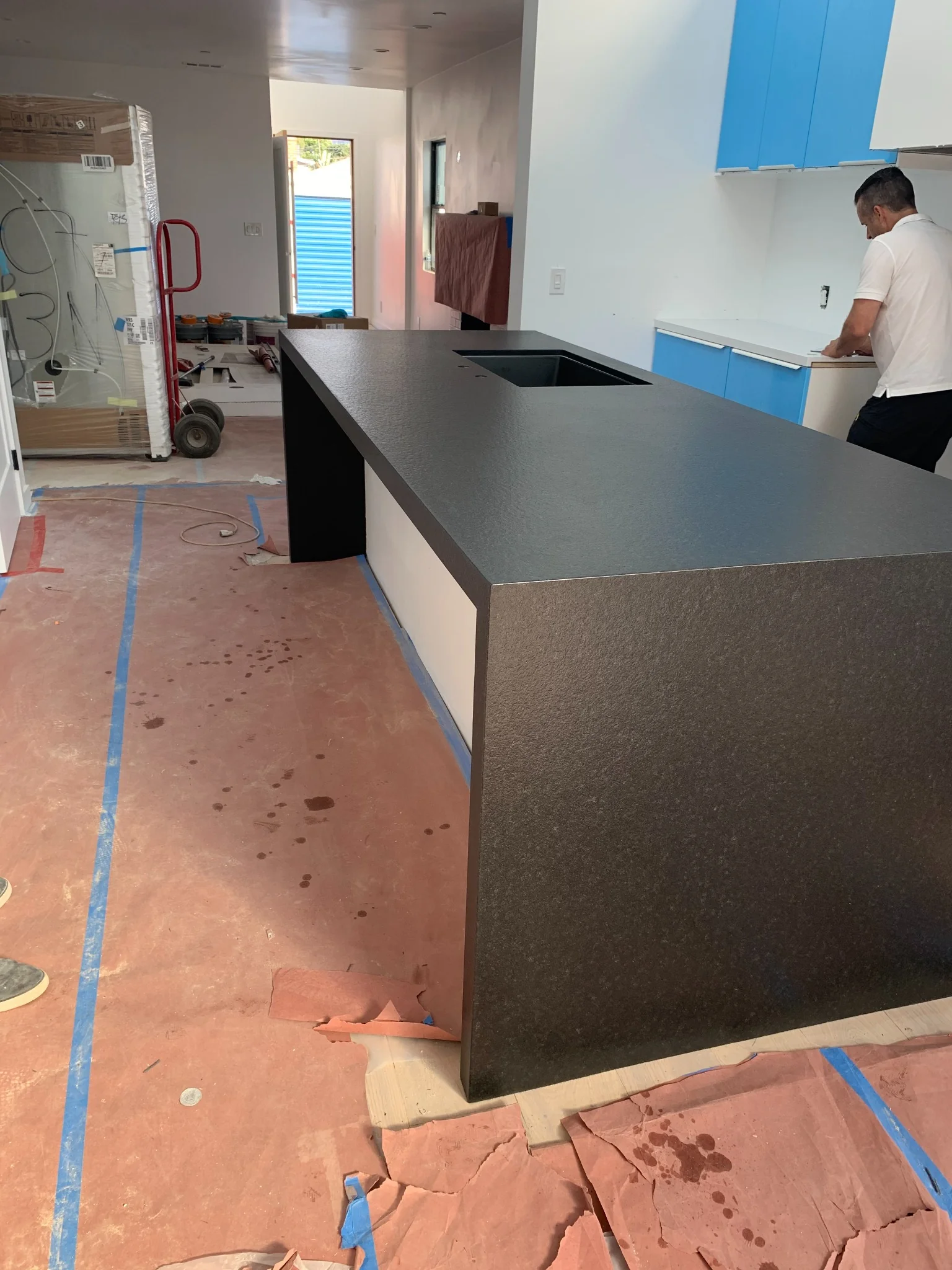 Black Absolute leather-finish waterfall island with integrated sink in a modern kitchen