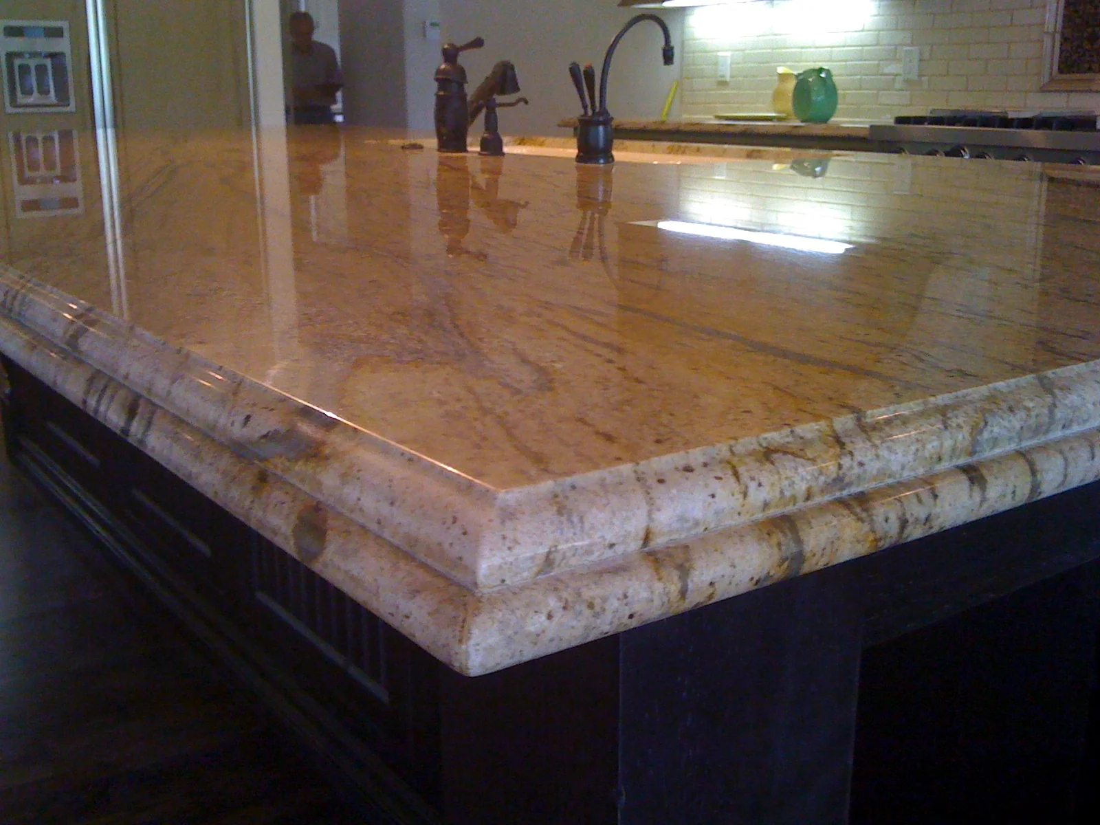 Close-up of a polished granite kitchen island countertop with Ogee-bullnose edge detail