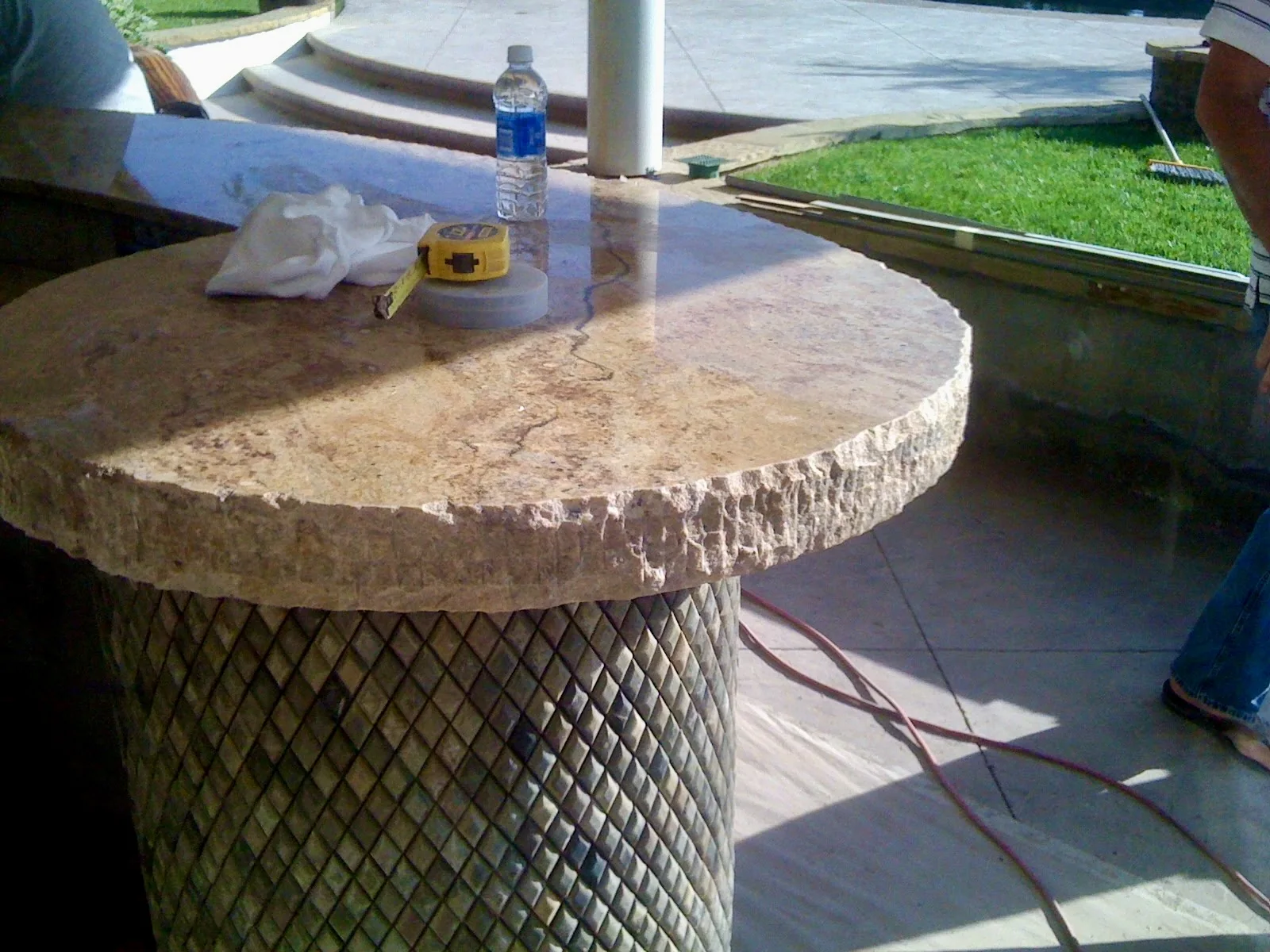 Close detail of chiseled edge outdoor stone countertop on curved patio bar