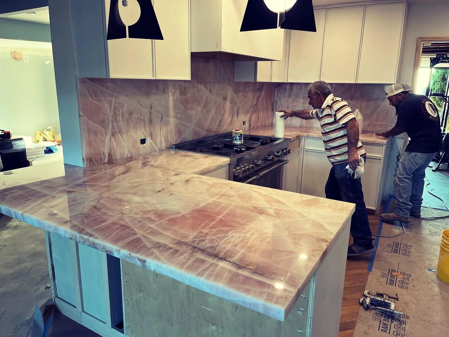 Pink Cristallo quartzite kitchen countertops and full-height backsplash during installation