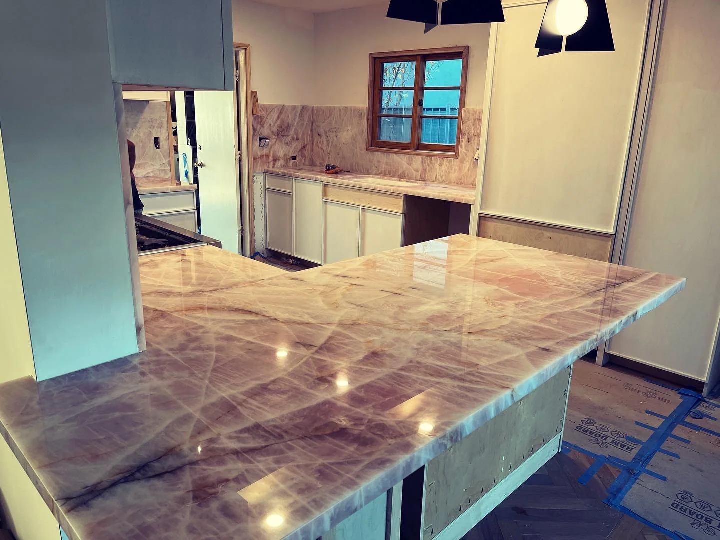 Pink Cristallo quartzite kitchen island with matching countertops and full-height backsplash