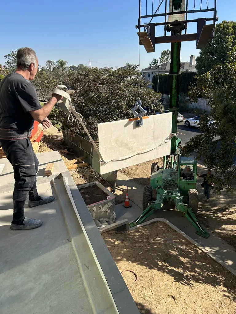 Large green stone slab being lifted for bathroom installation