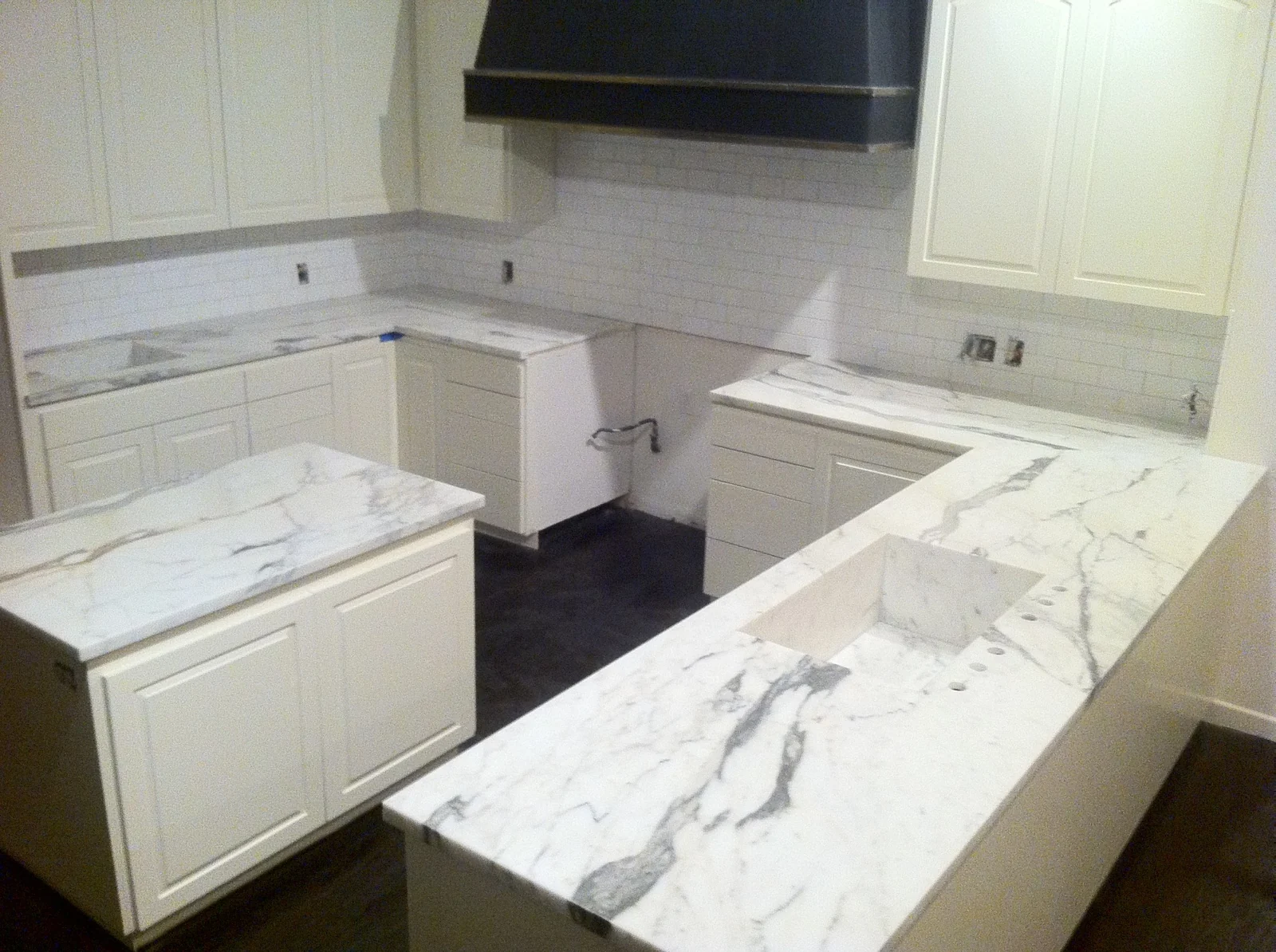 Honed Calacatta marble kitchen peninsula with integrated sink and matching perimeter counters