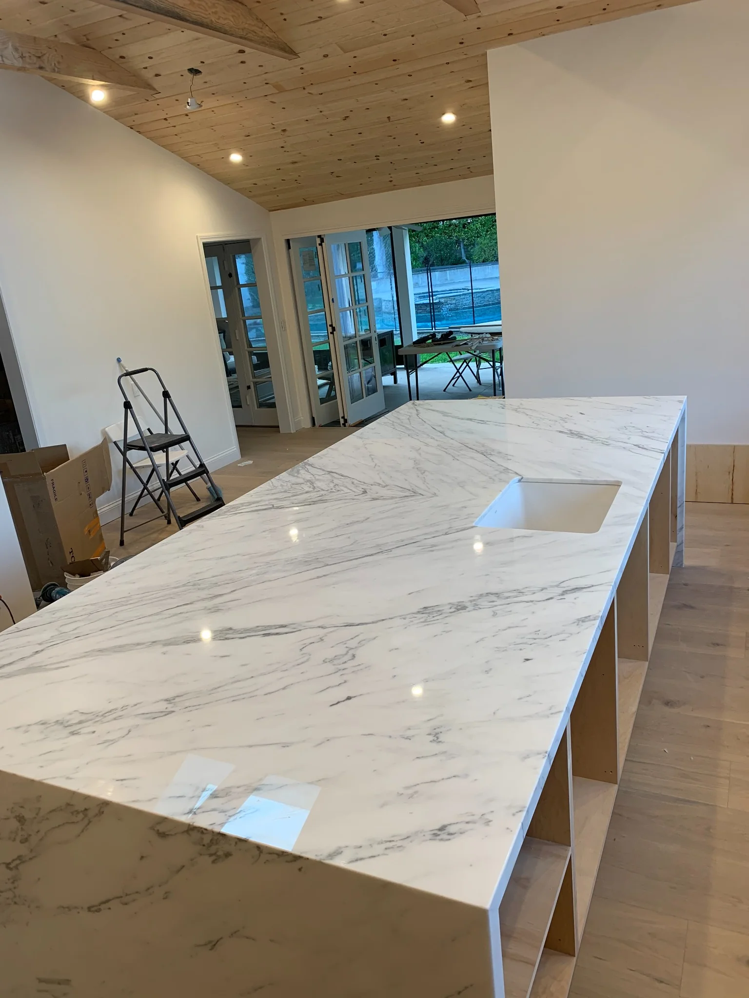 Arabescato marble waterfall island with polished surface and integrated sink