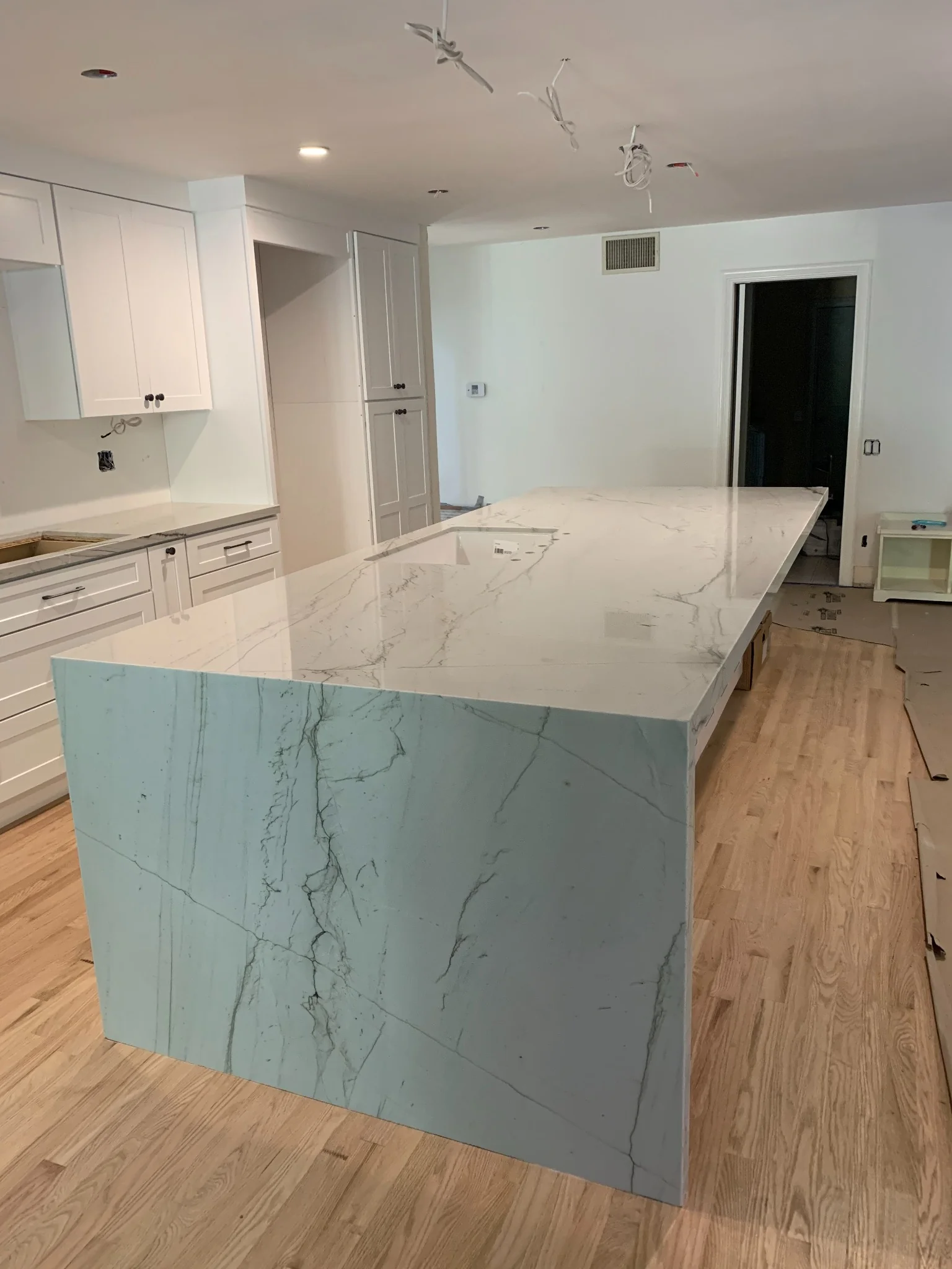 White Macaubas quartzite waterfall island with mitered sides in a Los Angeles kitchen