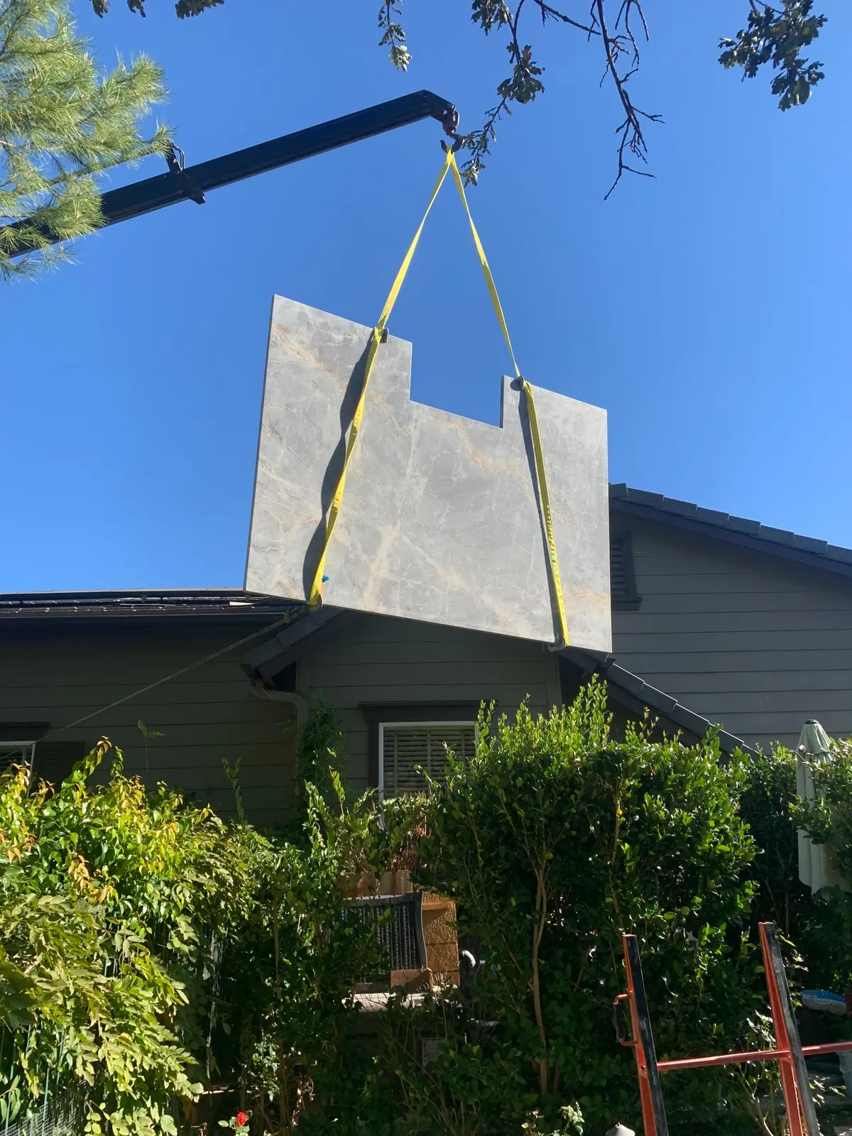 Large stone slab lifted into position for custom countertop installation in Southern California